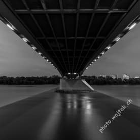 Bridge underside over river at night Warsaw Poland