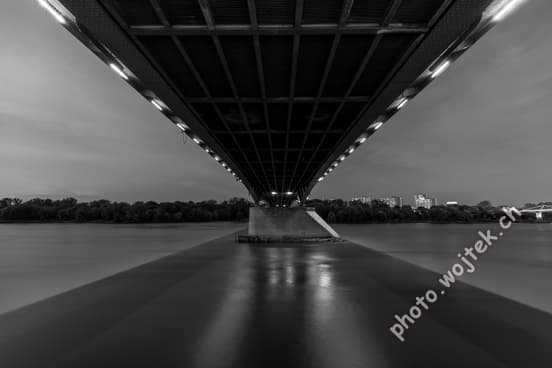 Bridge underside over river at night Warsaw Poland