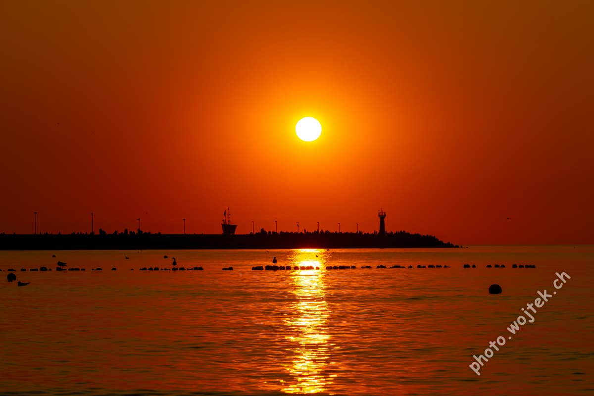 Sunset over harbor pier Kolobrzeg Poland