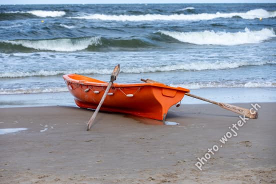 Orange rowboat on beach Kolobrzeg Poland