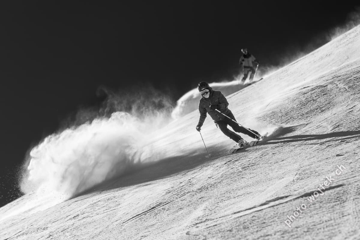 Skiers carving powder slope Schladming Austria