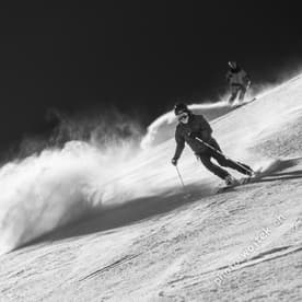 Skiers carving powder slope Schladming Austria
