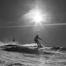 Skiers on slope under sun Schladming Austria