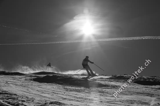 Skiers on slope under sun Schladming Austria